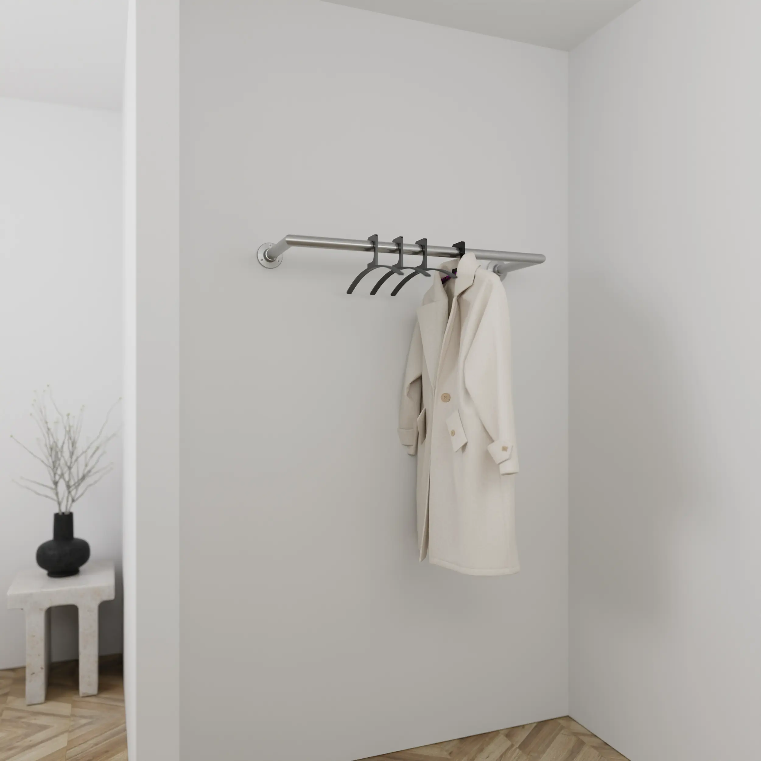 Wandgarderobe Sonel rund Edelstahl in einem Interieur mit Kleidung an der Wand montiert.