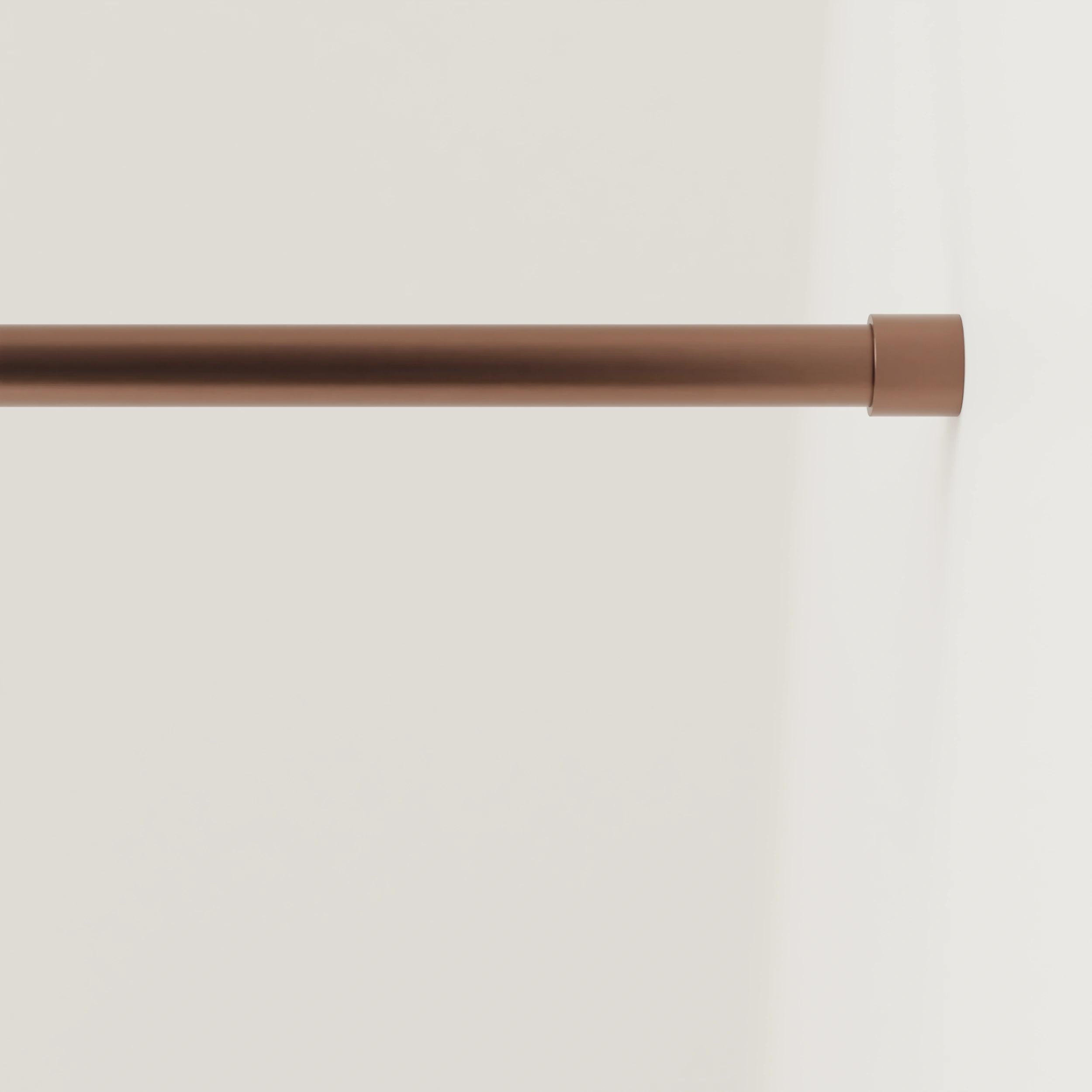 Garderobestang B rond brons aan de wand gemonteerd in een interieur met kleding.