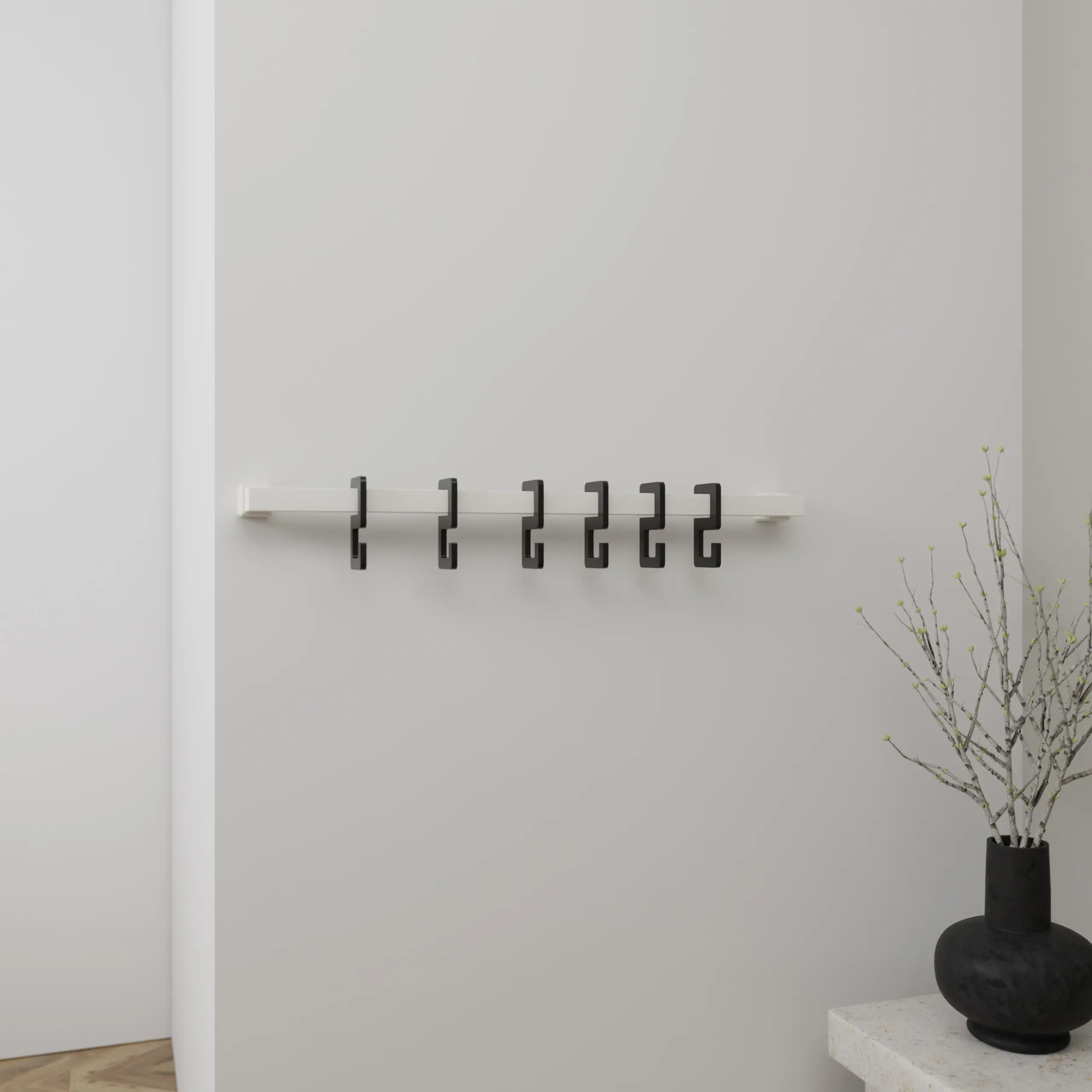 Wandkapstok Hylan vierkant wit aan de wand gemonteerd in een interieur met kleding.