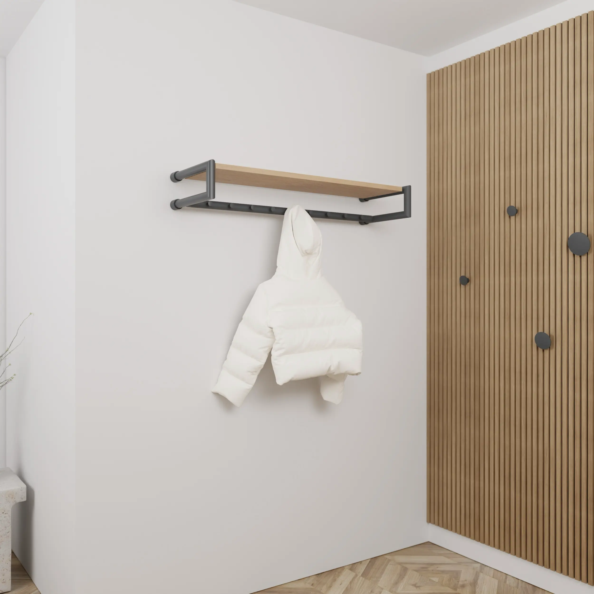 Kapstok Ulena rond antraciet aan de wand gemonteerd in een interieur met kleding.