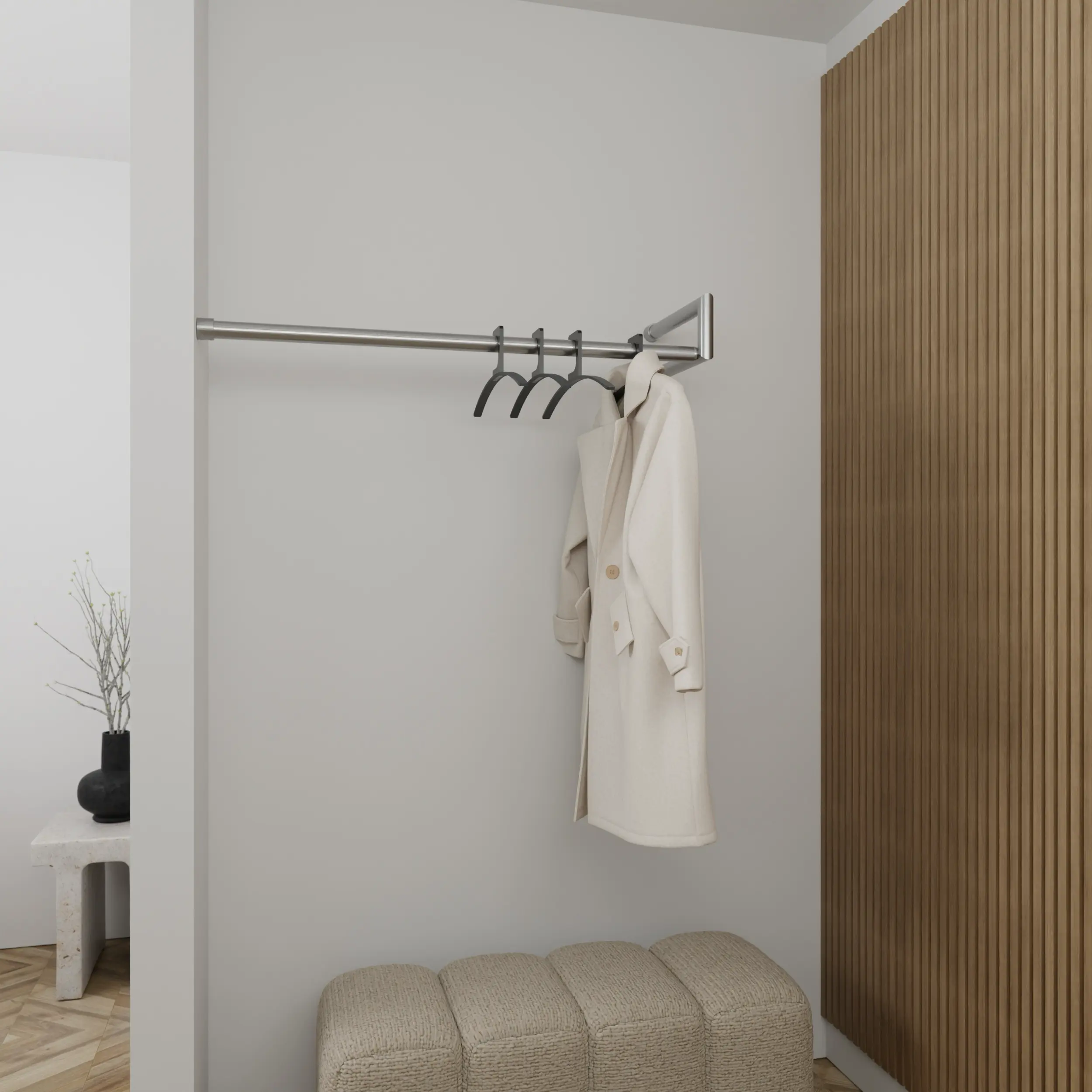 Wall-mounted coat rack Lorien round stainless steel left corner mounted in an interior with clothing.