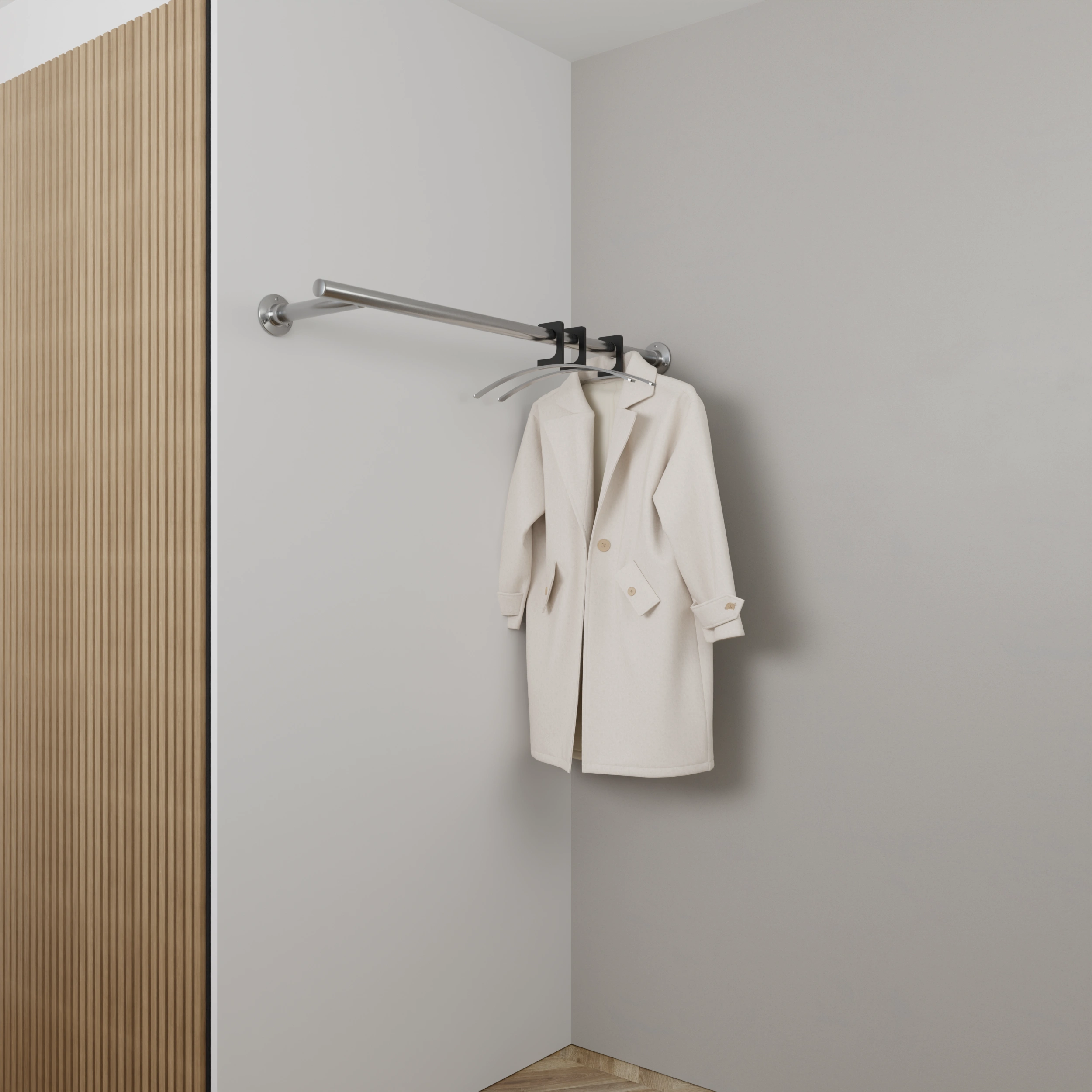 Wandkapstok Zolma rond RVS aan de wand gemonteerd in een interieur met kleding.