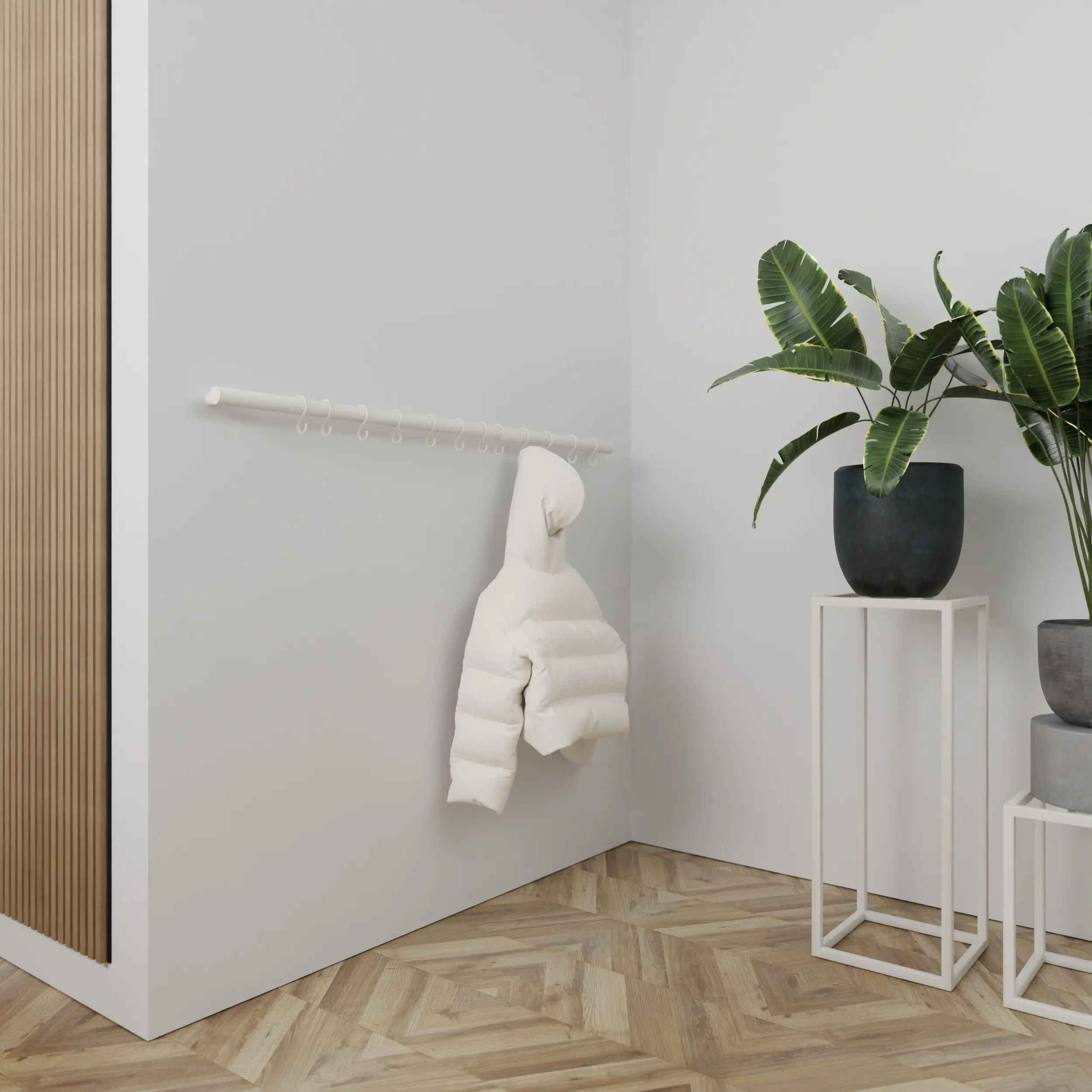 Wandkapstok Hylan rond wit aan de wand gemonteerd in een interieur met kleding.
