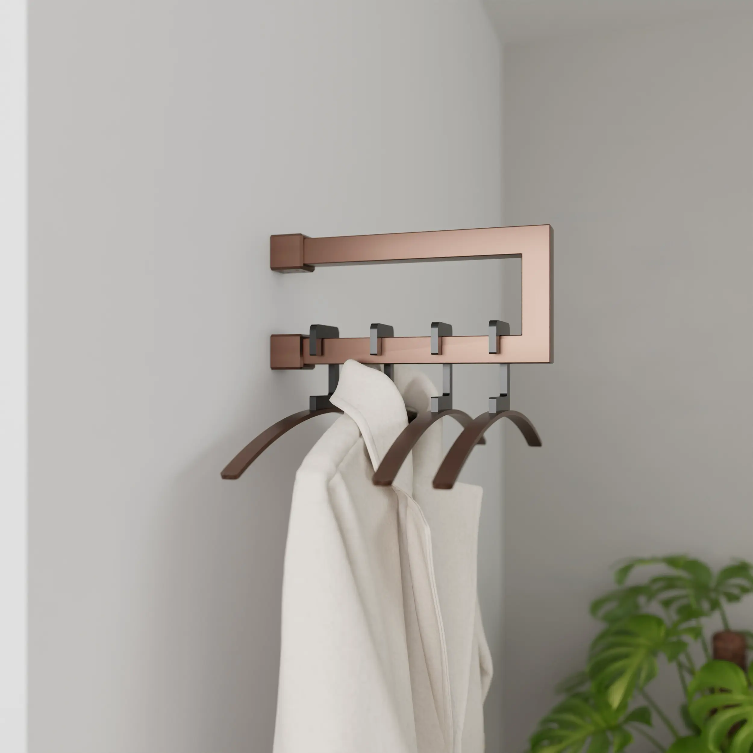 Wandgarderobe Eslin quadratisch bronze in einem Interieur mit Kleidung an der Wand montiert.