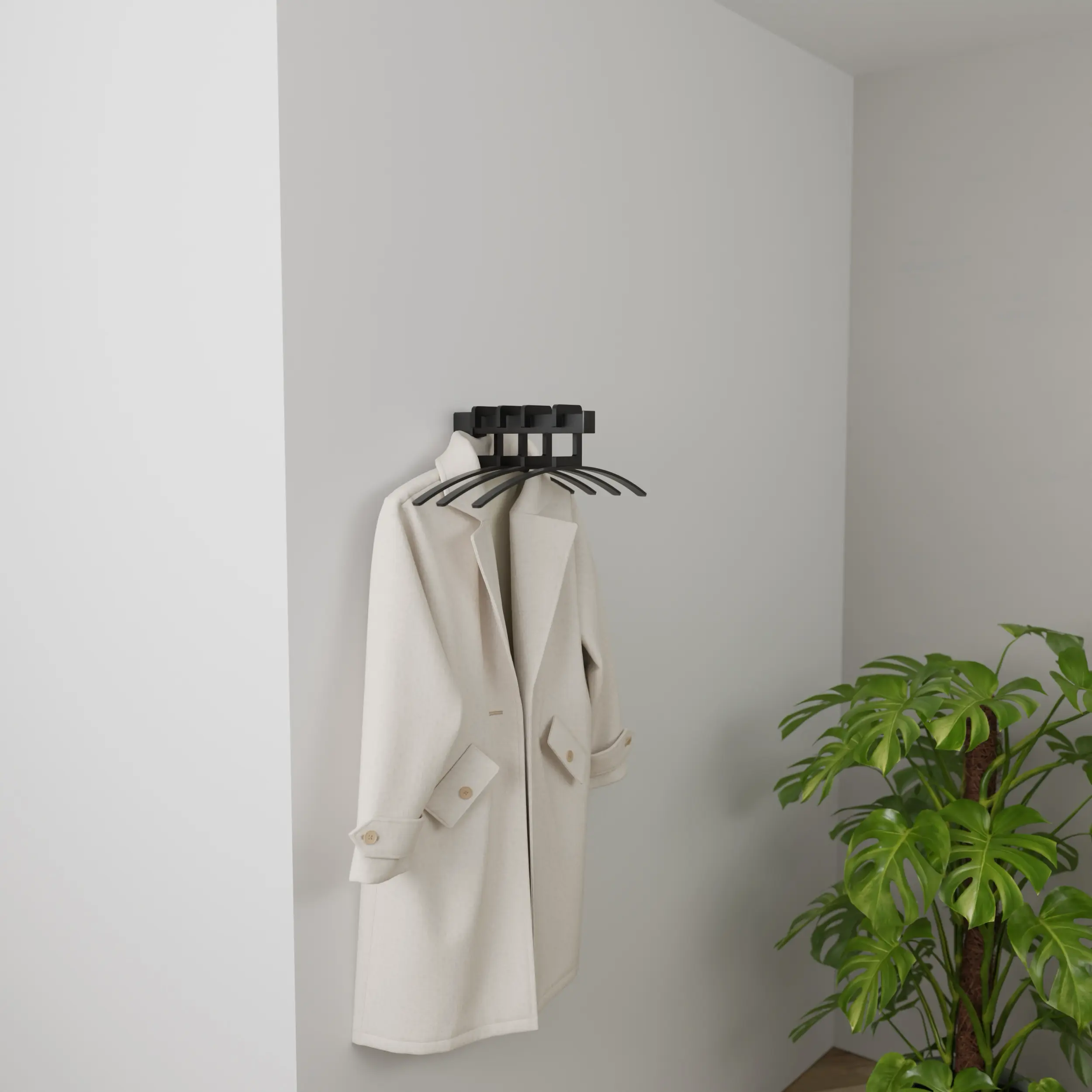 Wandkapstok Imora vierkant zwart in een licht interieur met kleding aan hangers en een groene plant.