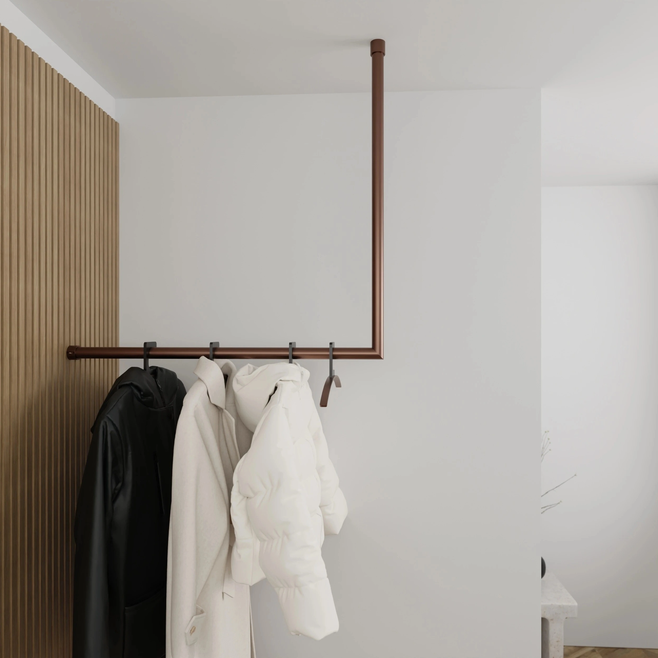 Kapstok Lovan rond brons aan de wand gemonteerd in een interieur met kleding.