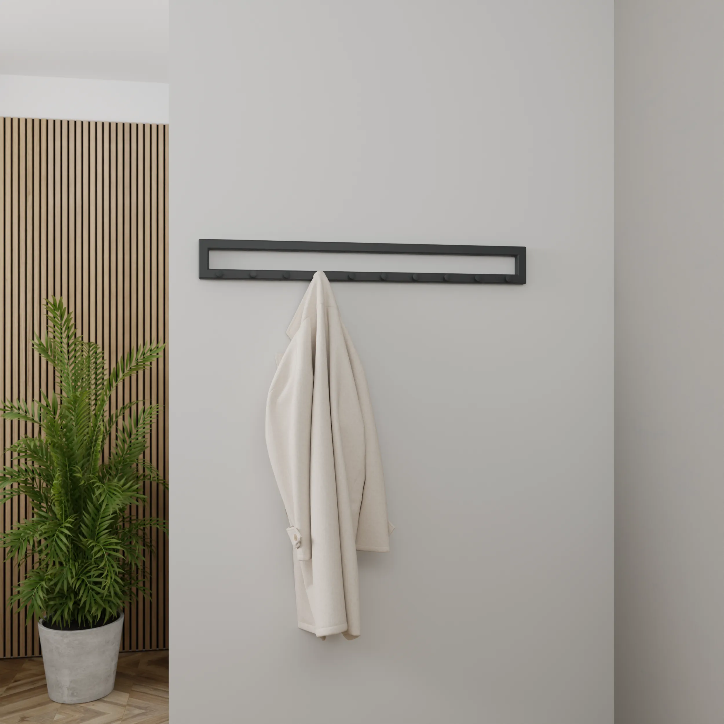 Wandgarderobe Finn in anthrazit an einer hellen Wand mit einer Jacke an den Haken.