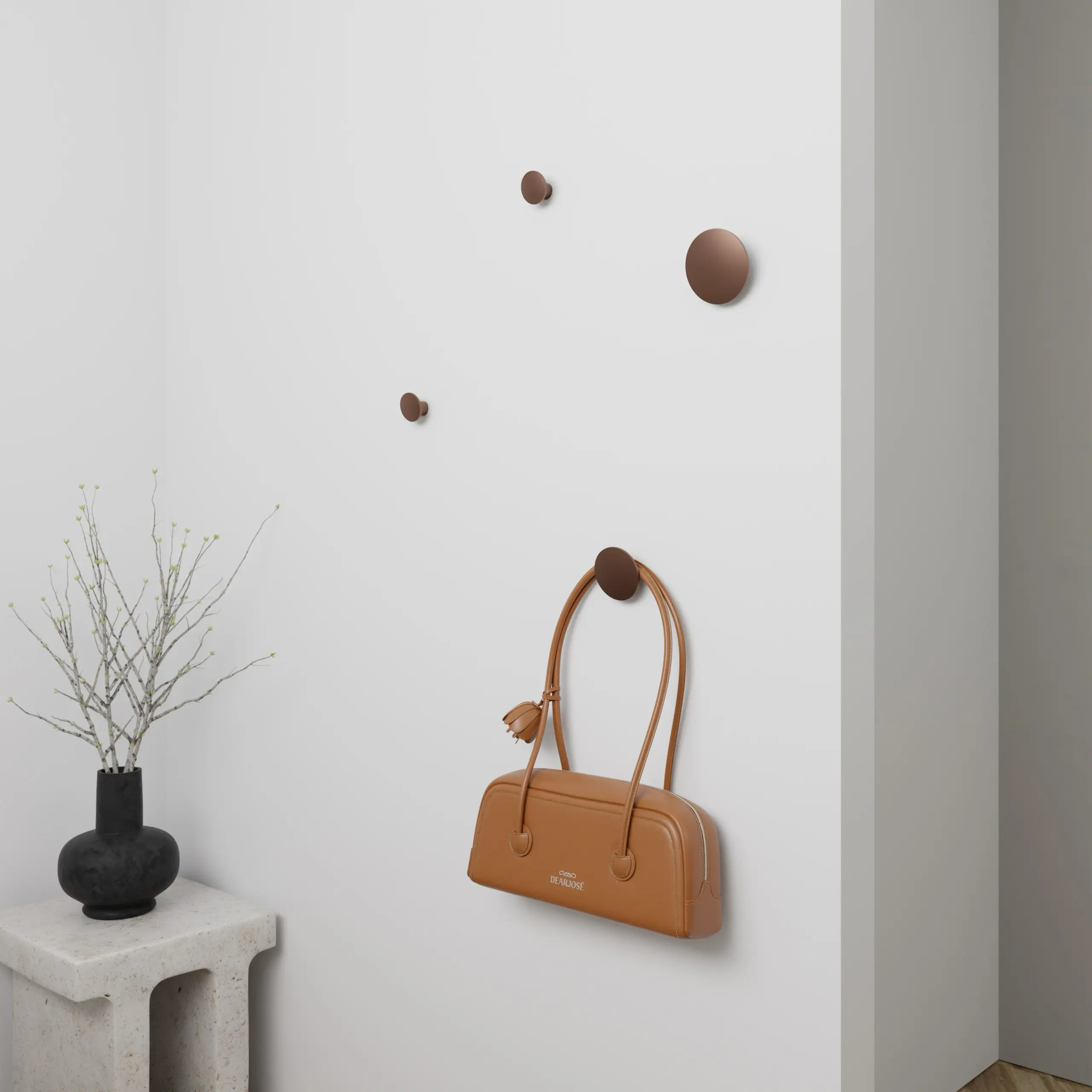 Wandkapstok Halo rond brons aan de wand gemonteerd met een tas eronder.
