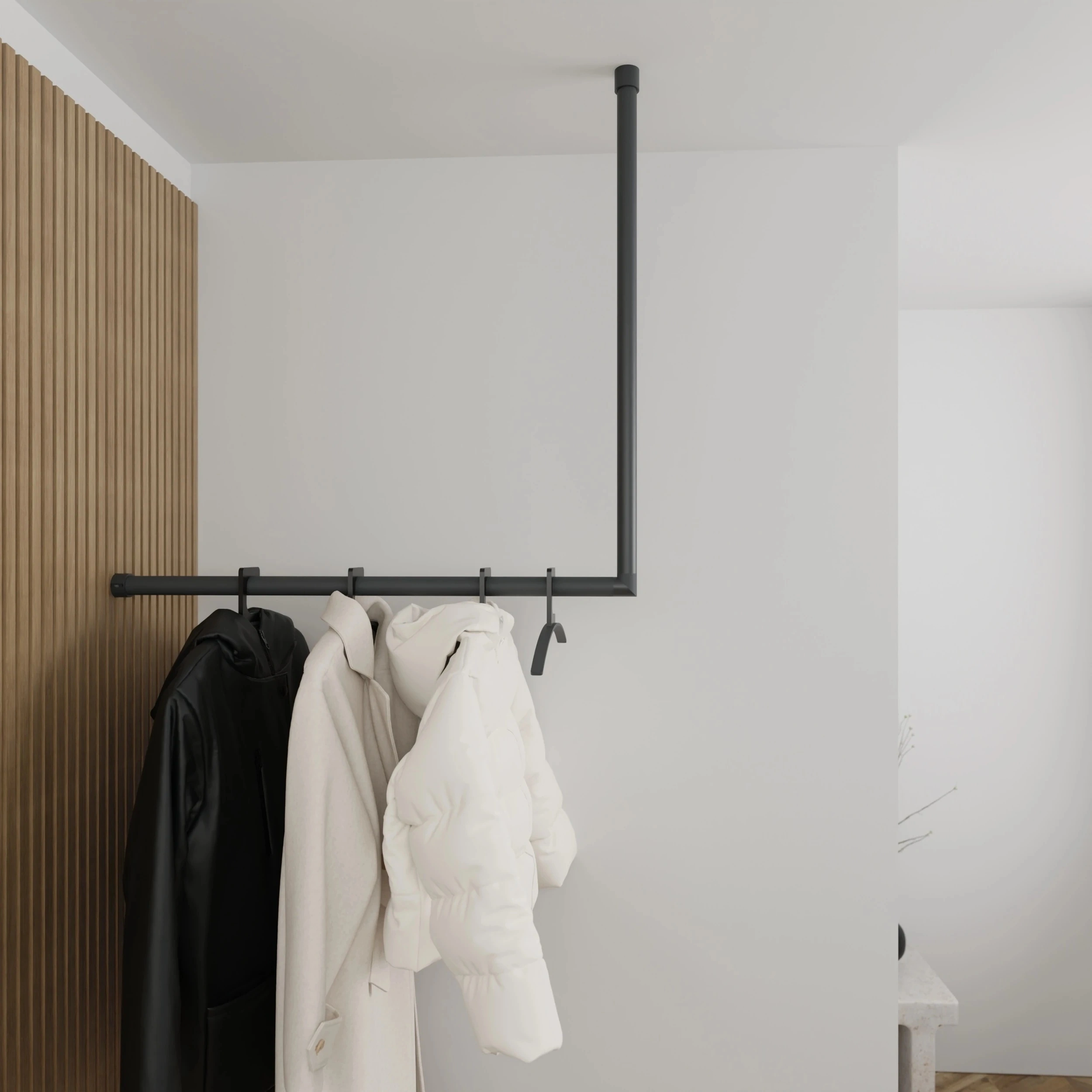 Kapstok Lovan rond antraciet aan de wand gemonteerd in een interieur met kleding.