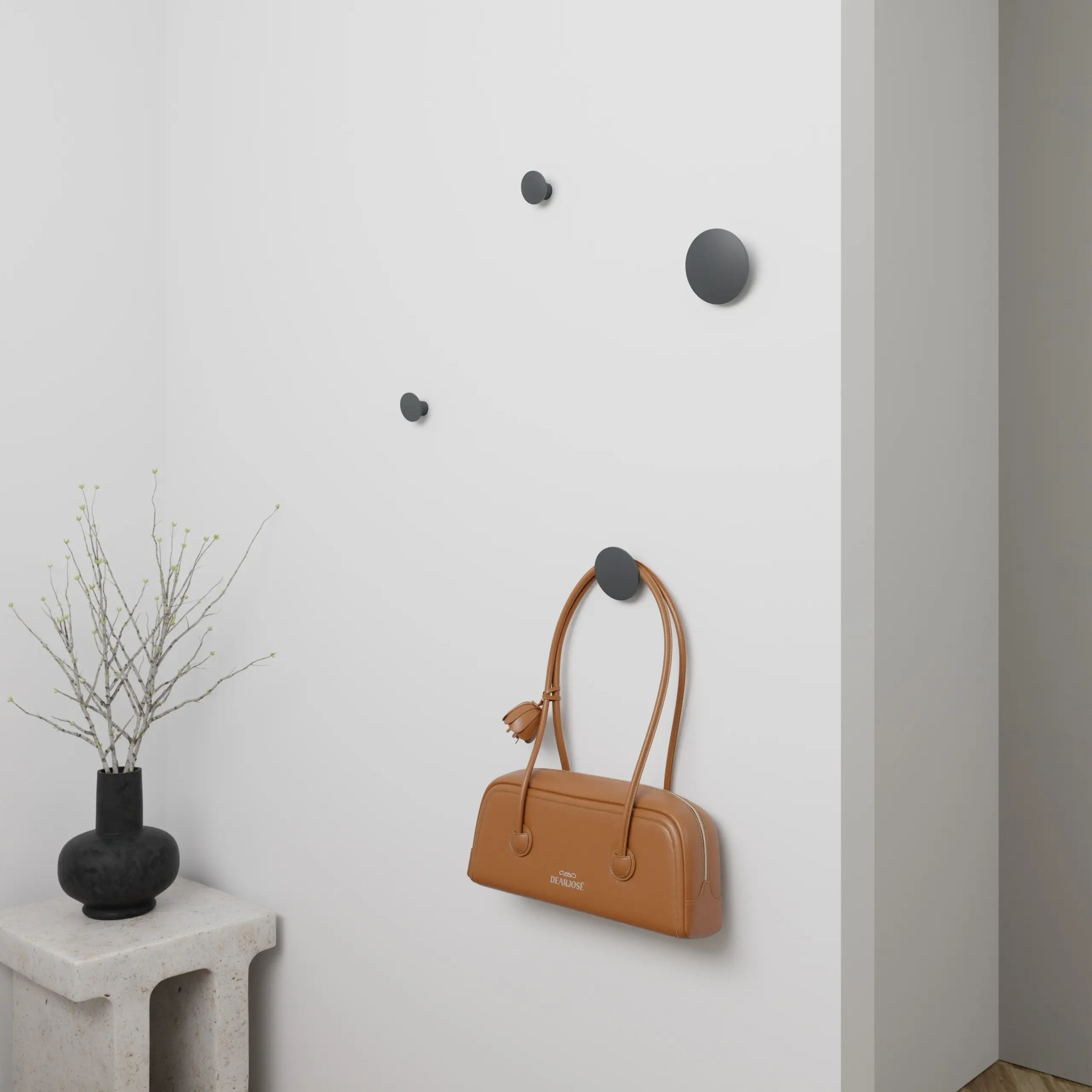 Haken Halo rund anthrazit an der Wand mit einer Tasche darunter montiert.