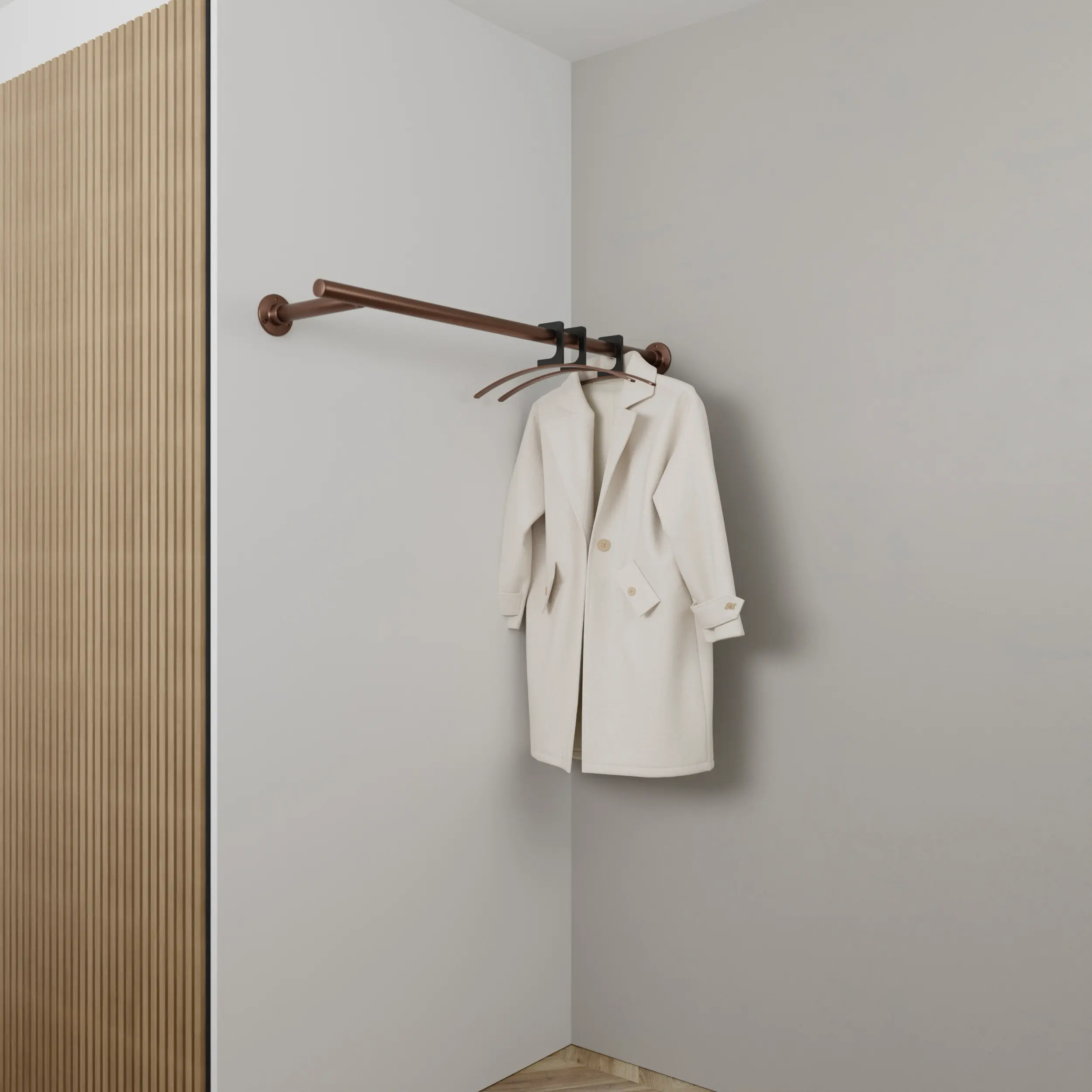 Wandkapstok Zolma rond brons aan de wand gemonteerd in een interieur met kleding.