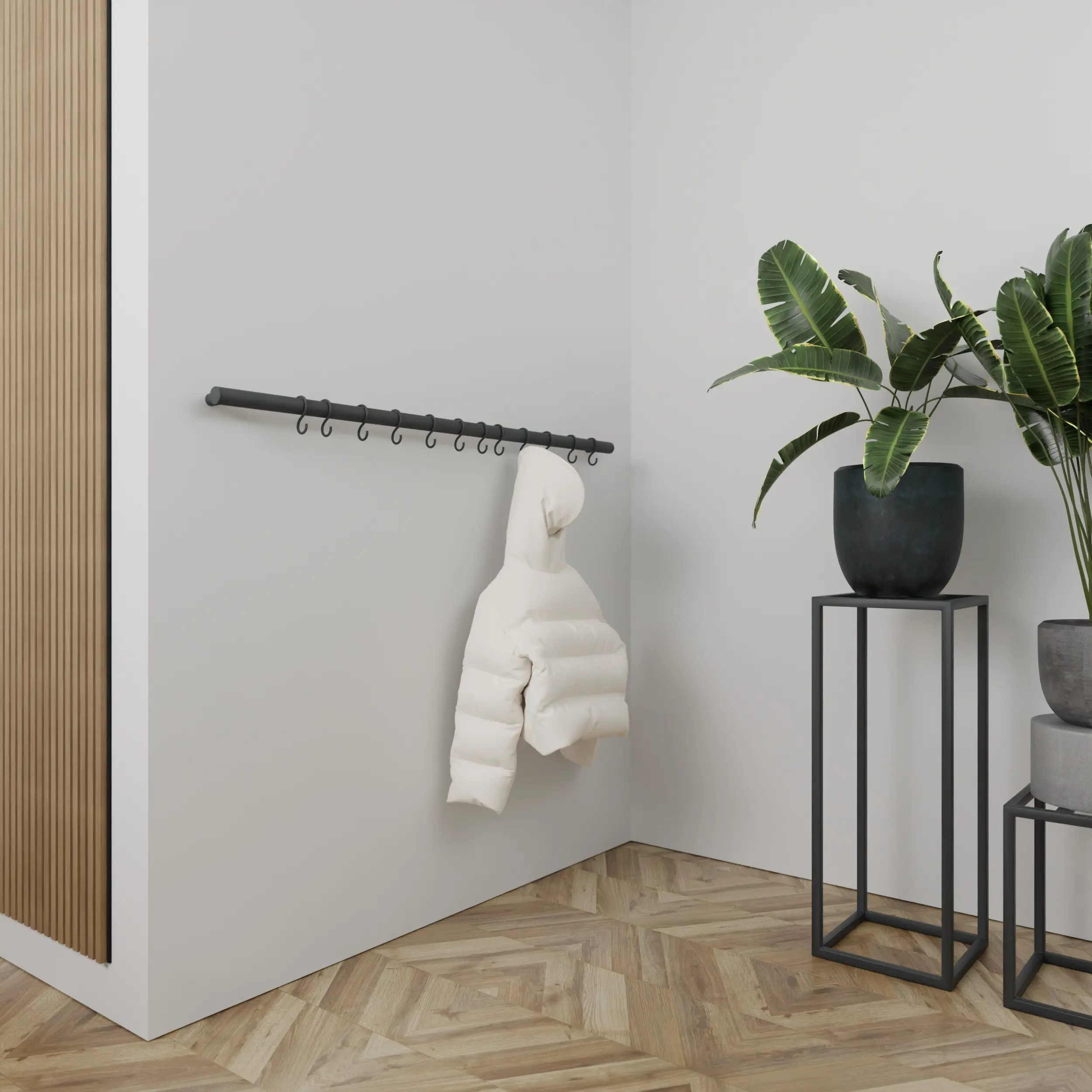 Wandkapstok Hylan rond antraciet aan de wand gemonteerd in een interieur met kleding.