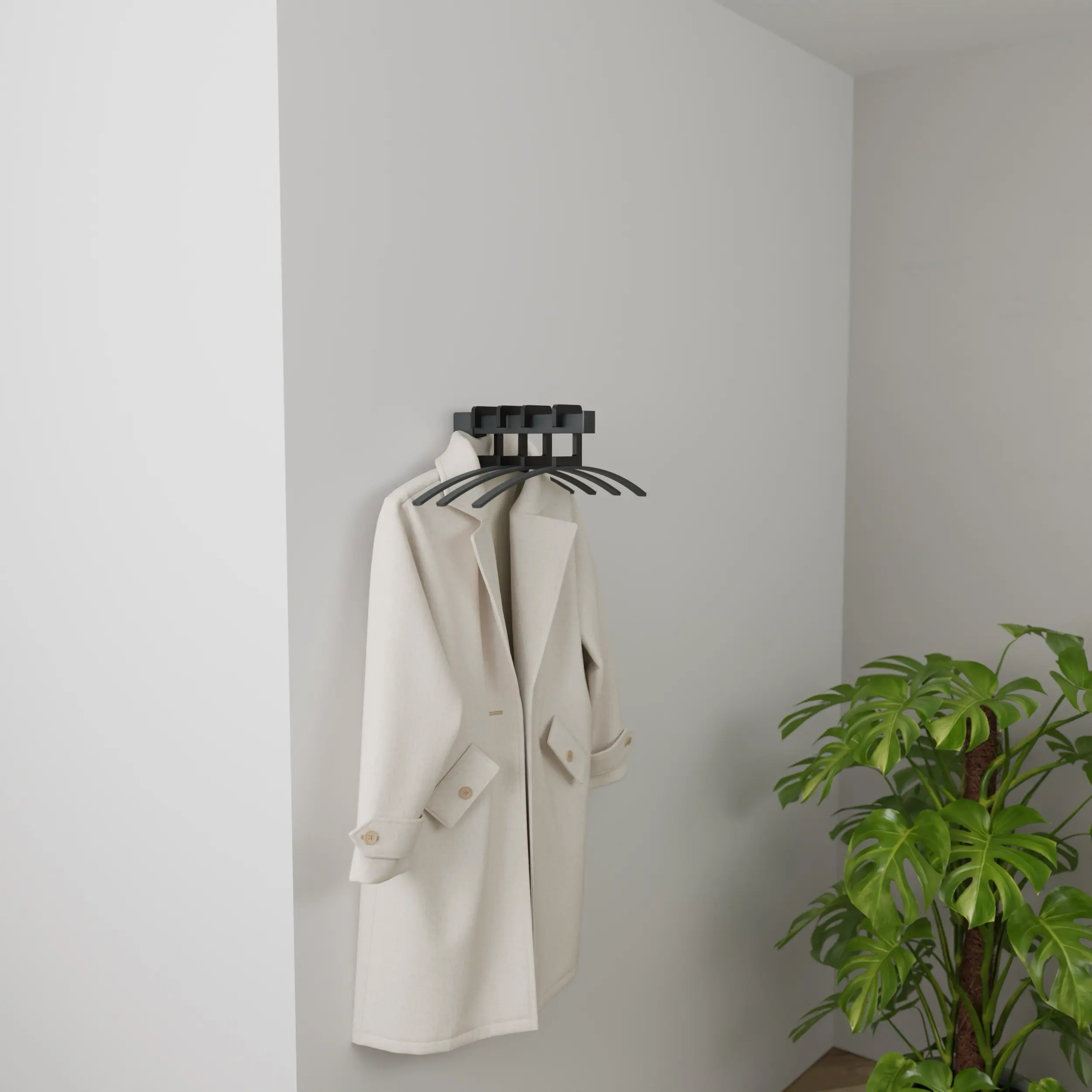 Wandgarderobe Imora quadratisch anthrazit in einem hellen Interieur mit Kleidung auf Bügeln und grüner Pflanze.