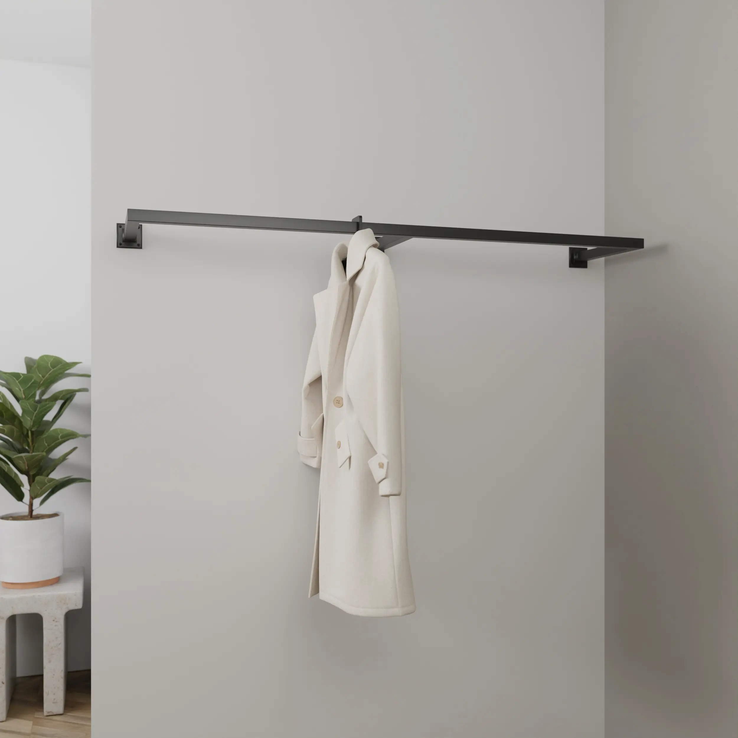 Wandkapstok Merlin vierkant zwart aan de wand gemonteerd in een interieur met kleding.