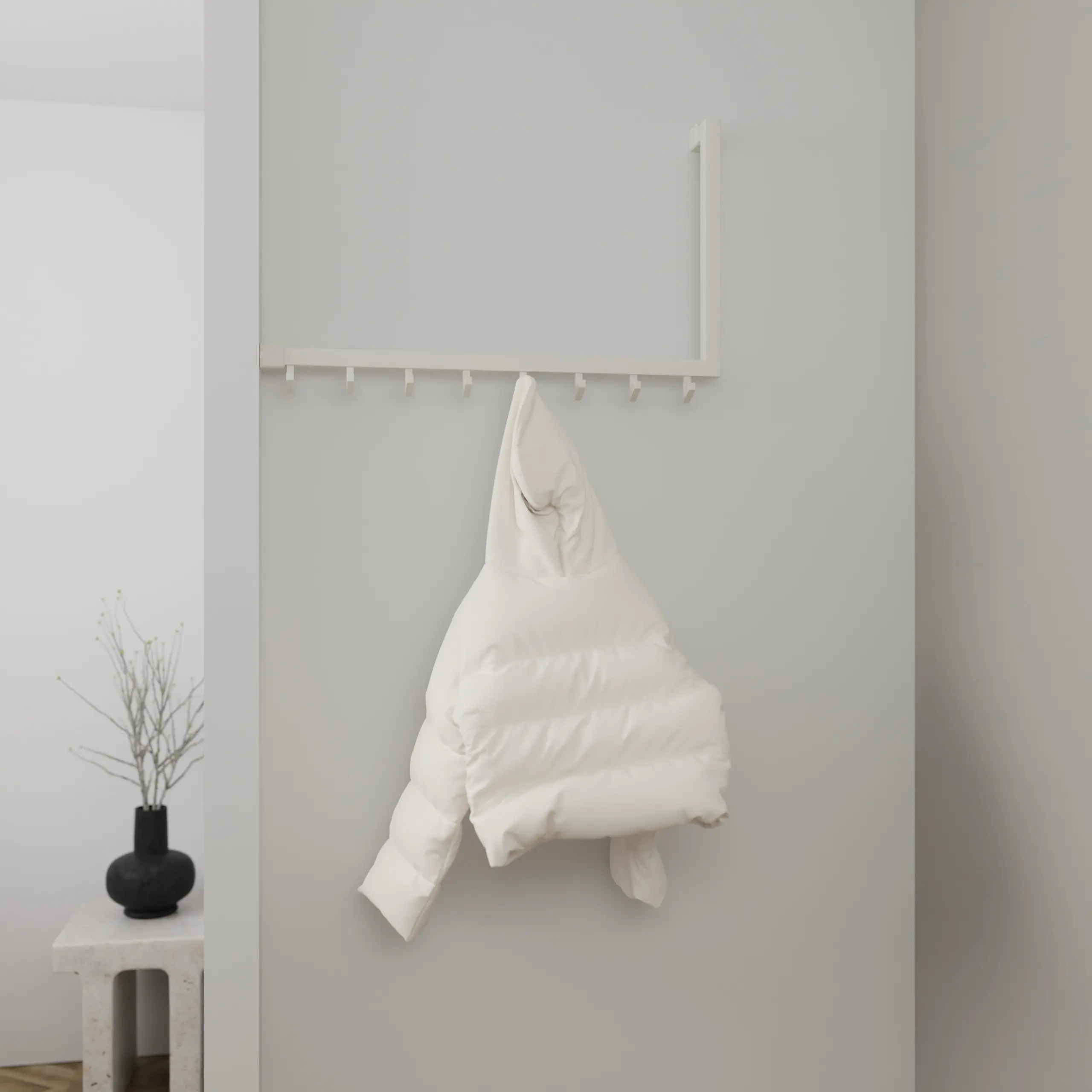 Wandkapstok Lune vierkant wit in een hoekopstelling aan de wand gemonteerd met kleding.
