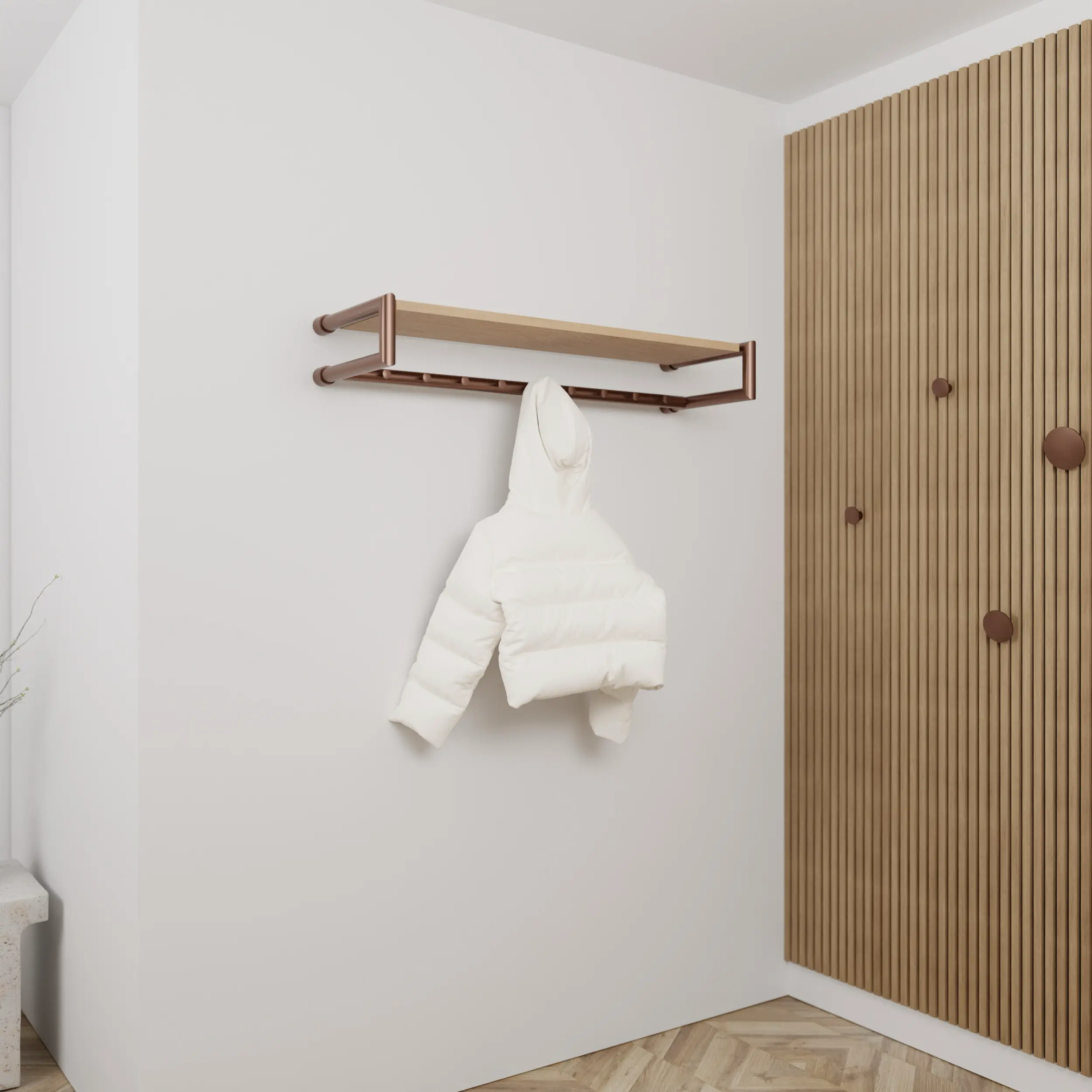 Garderobe Ulena rund bronze in einem Interieur mit Kleidung an der Wand montiert.