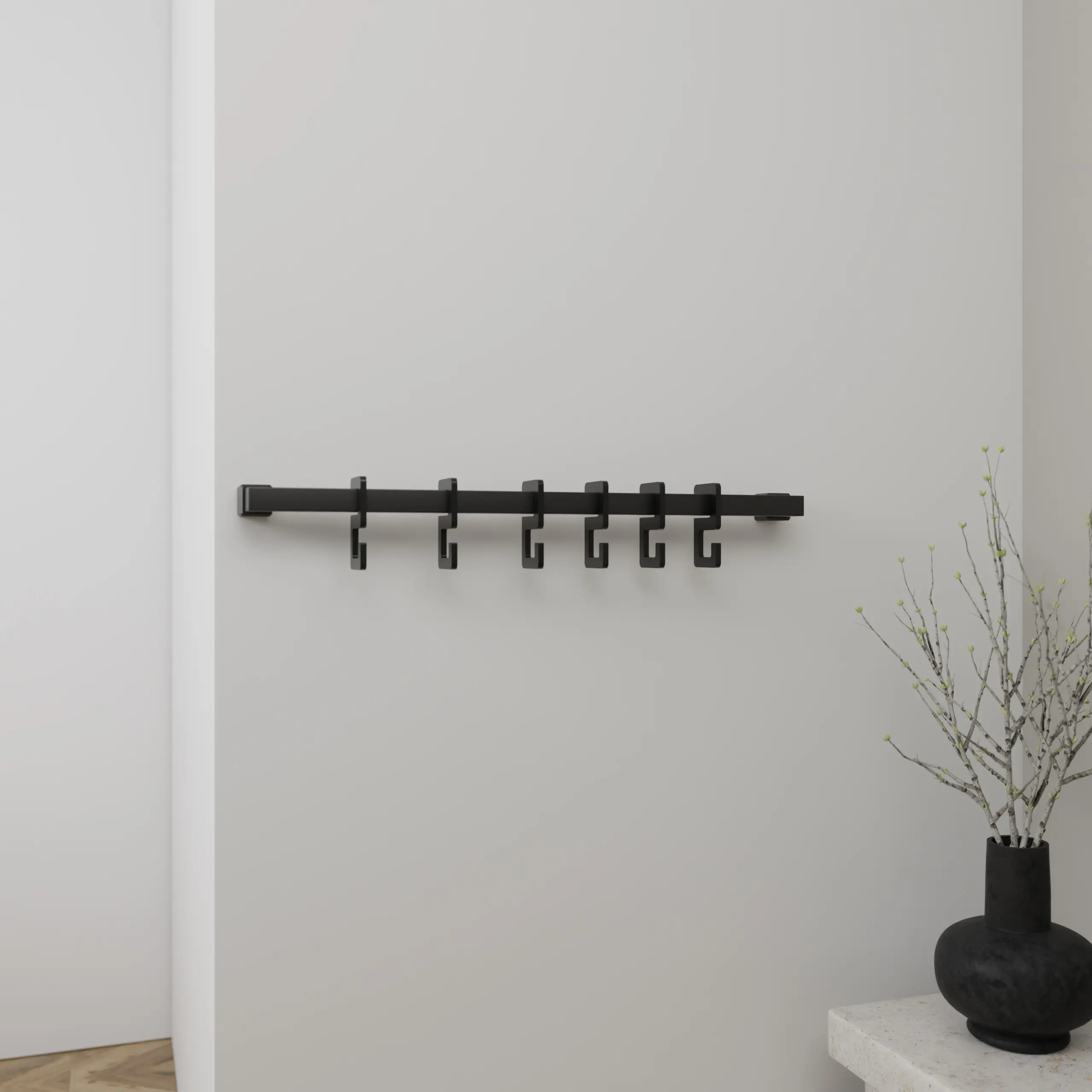 Wandgarderobe Hylan quadratisch schwarz in einem Interieur mit Kleidung an der Wand montiert.