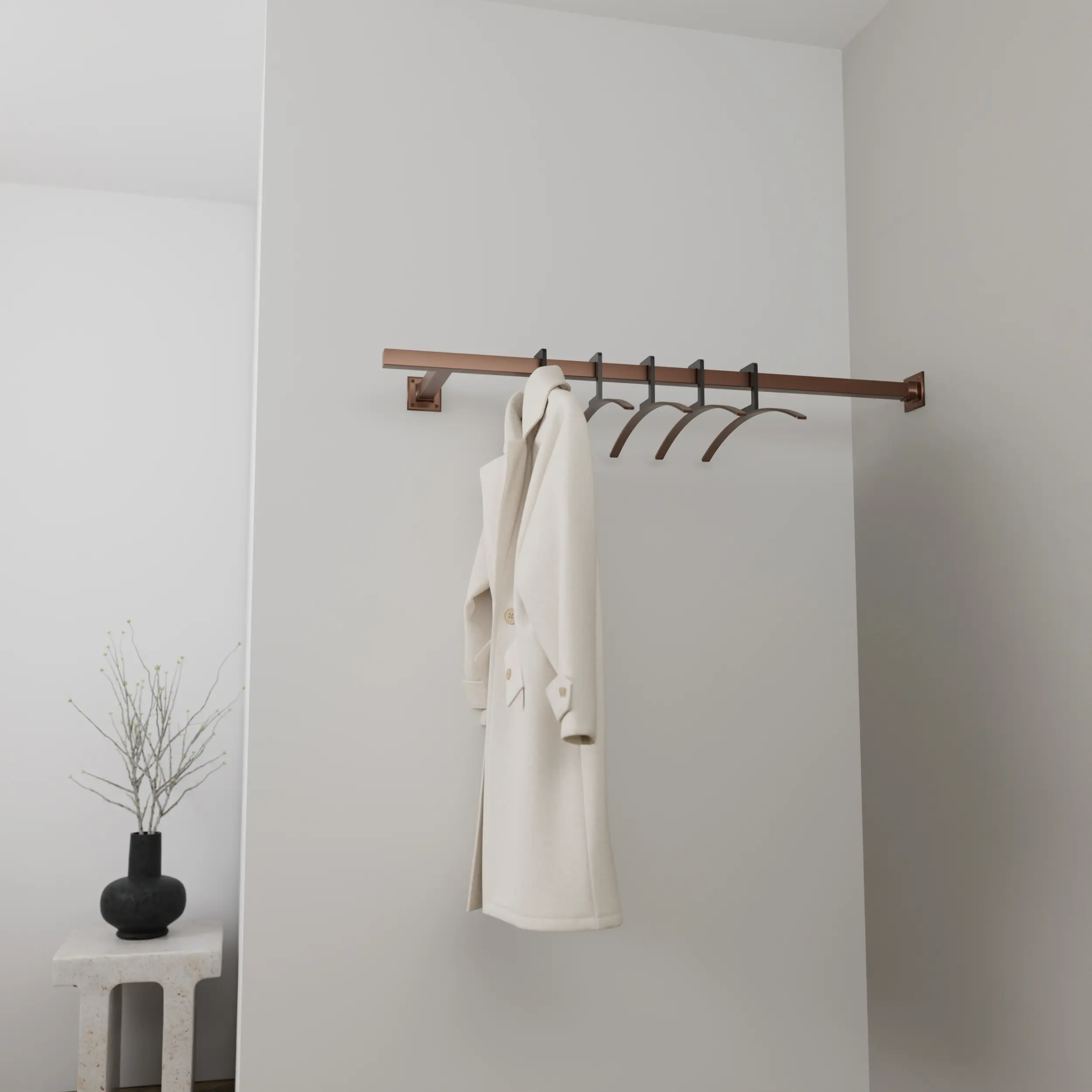 Wandgarderobe Zolma quadratisch bronze in einem Interieur mit Kleidung an der Wand montiert.