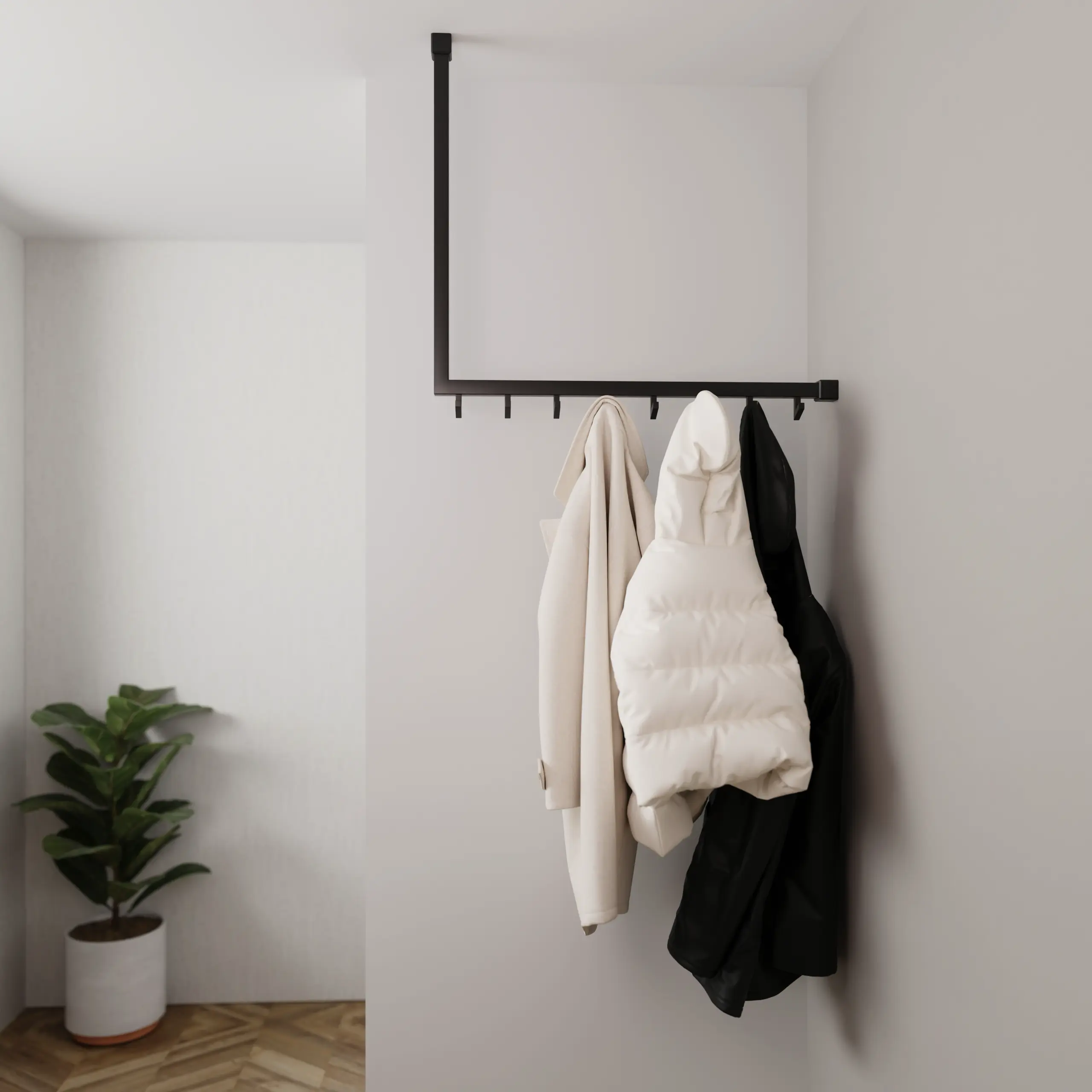 Kapstok Lovan vierkant zwart aan de wand gemonteerd in een interieur met kleding.
