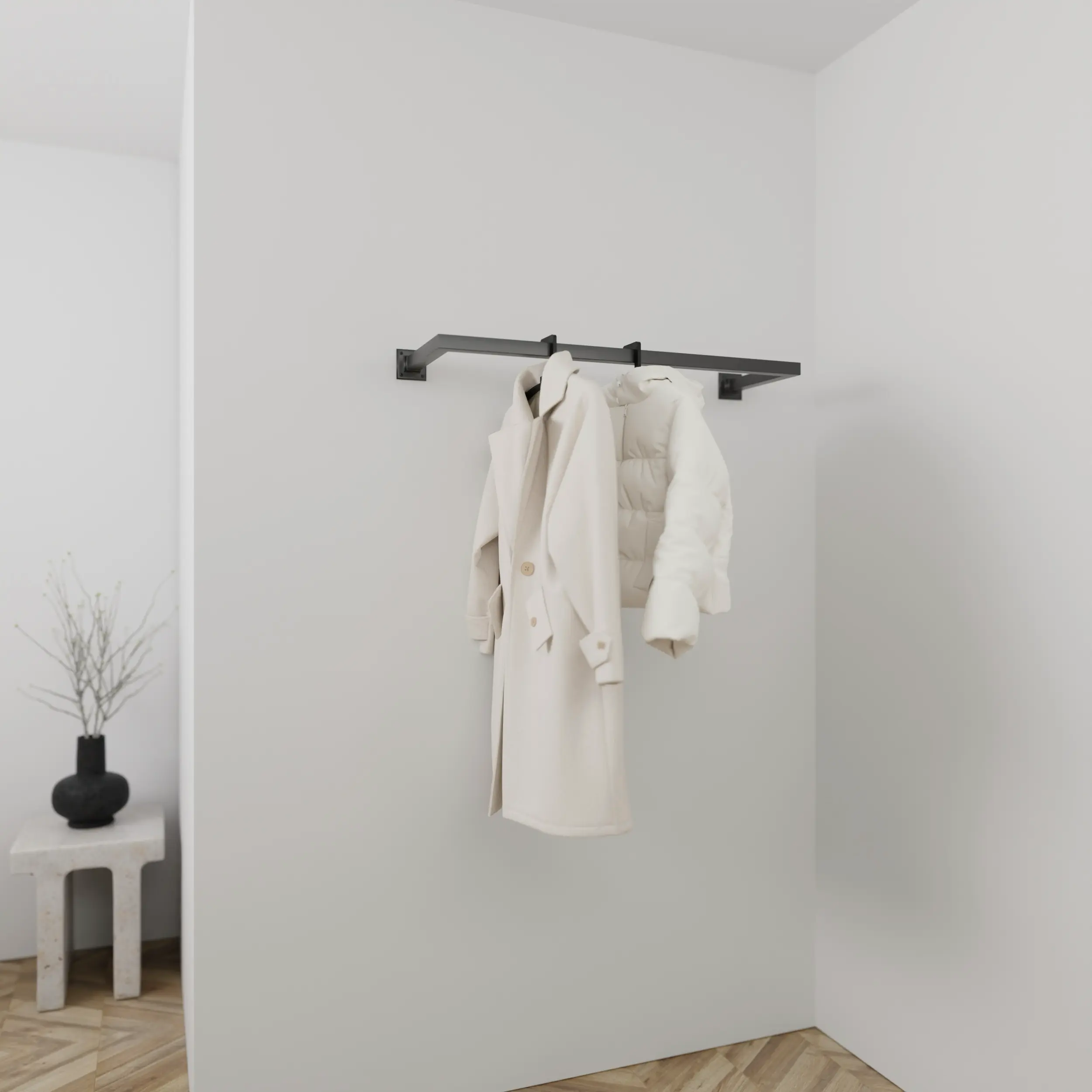 Wandkapstok Sonel vierkant zwart aan de wand gemonteerd in een interieur met kleding.