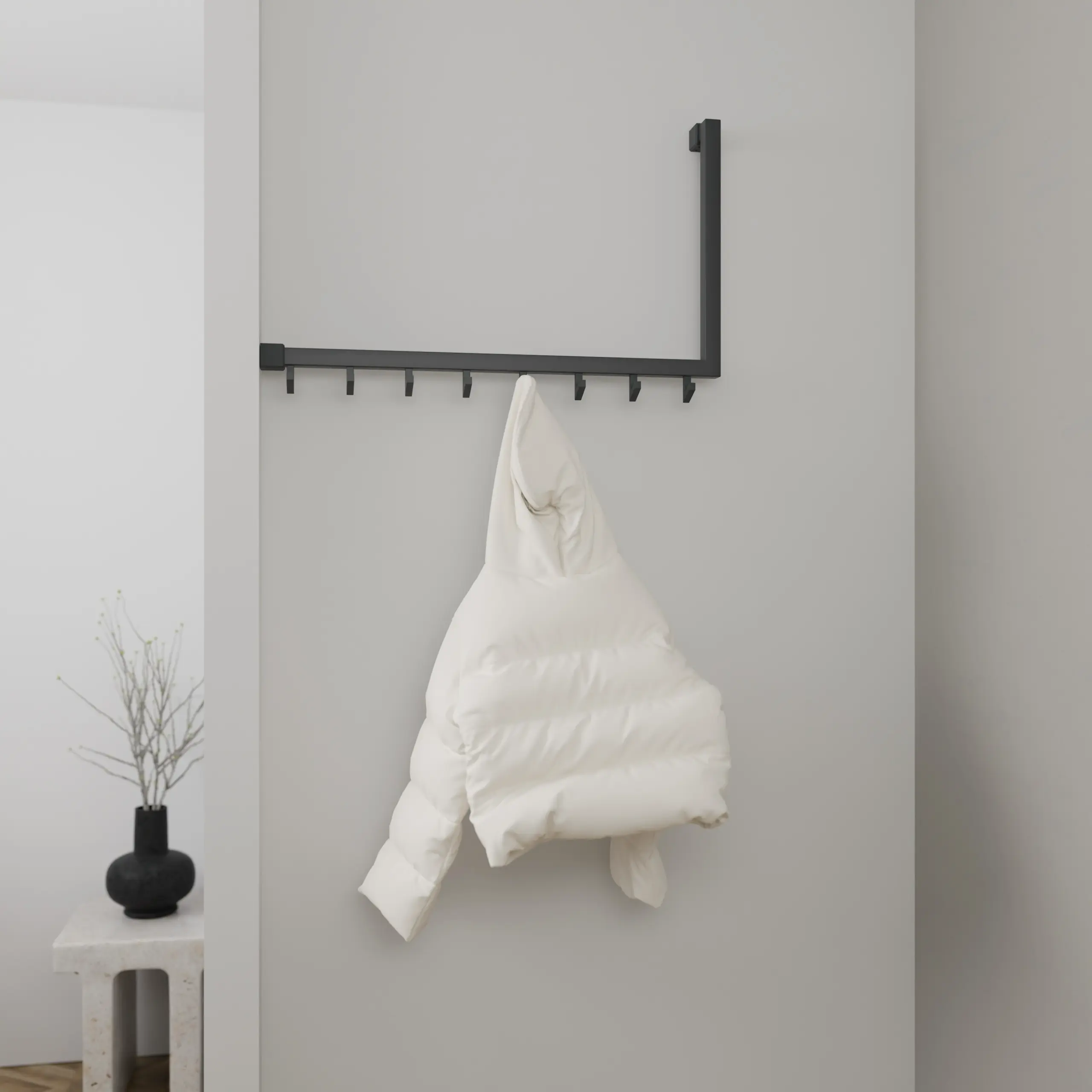 Wandkapstok Lune vierkant antraciet in een hoekopstelling aan de wand gemonteerd met kleding.